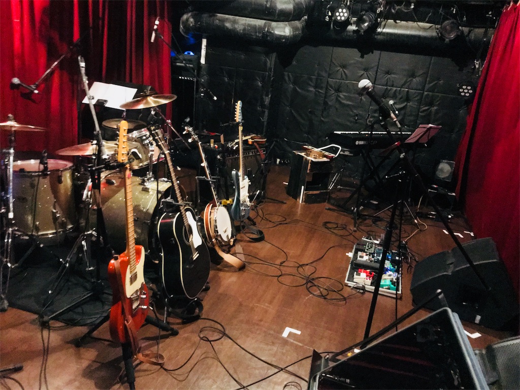 スターラウンジのステージ上写真。エレキギター2本、バンジョー、アコースティックギターなど様々な楽器が並ぶ。