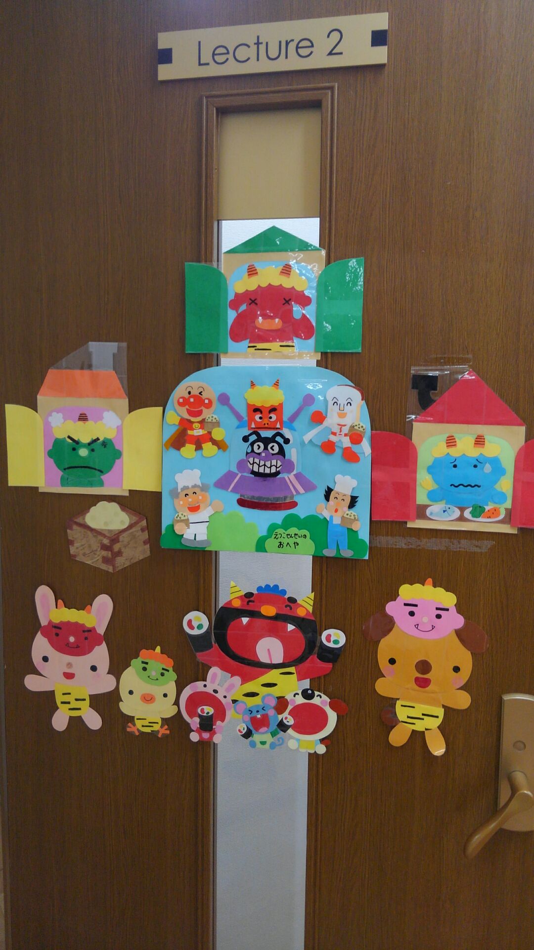 教室の扉に貼られた装飾の数々。鬼さん、豆、恵方巻など「節分」をテーマにした絵の他、アンパンマンのキャラクター達が豆まきをしているイラストも張られている。