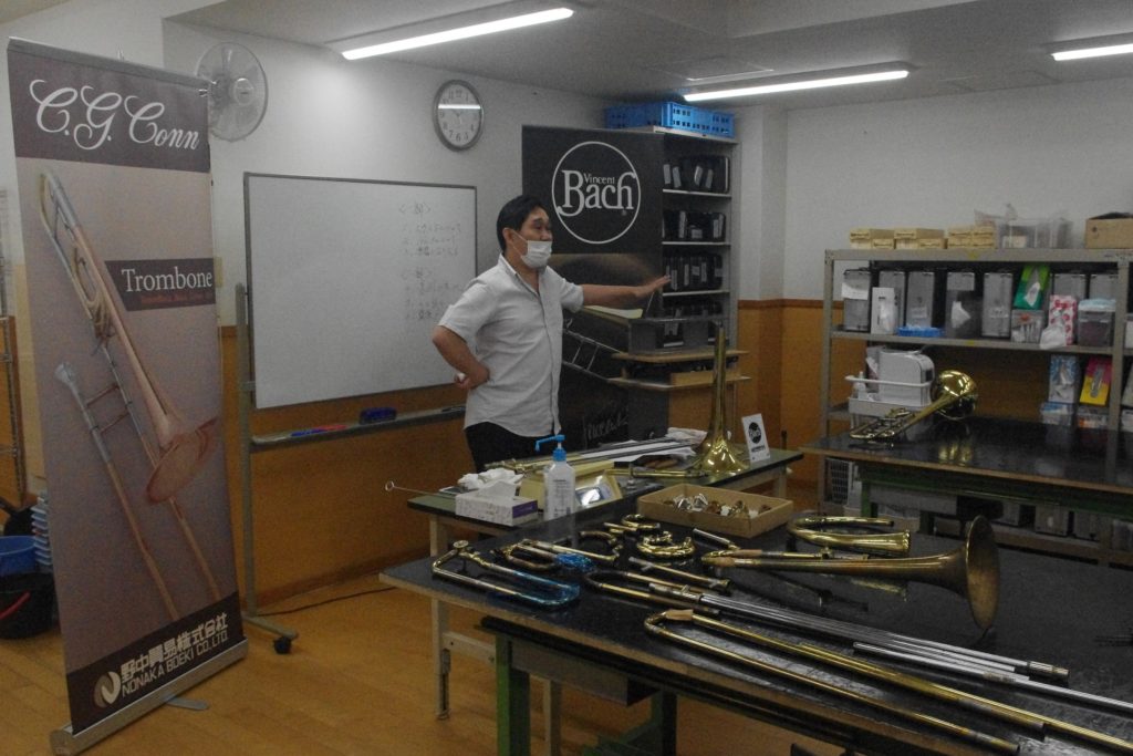 飯塚丈人氏と机に置かれたいくつかの管楽器