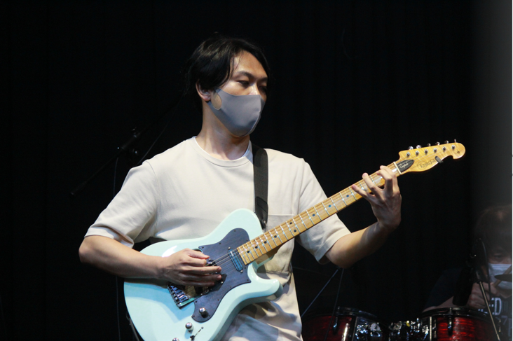 ギターを演奏する学生の江副氏