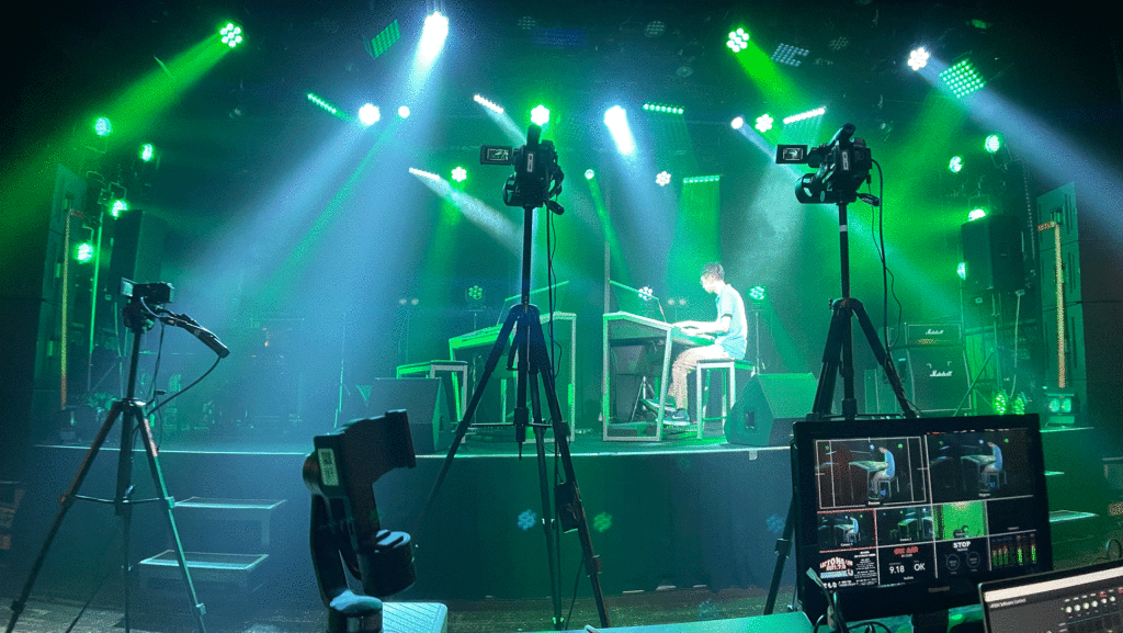 照明で照らされたステージ上でのエレクトーン演奏を撮影するカメラや映像配信機材