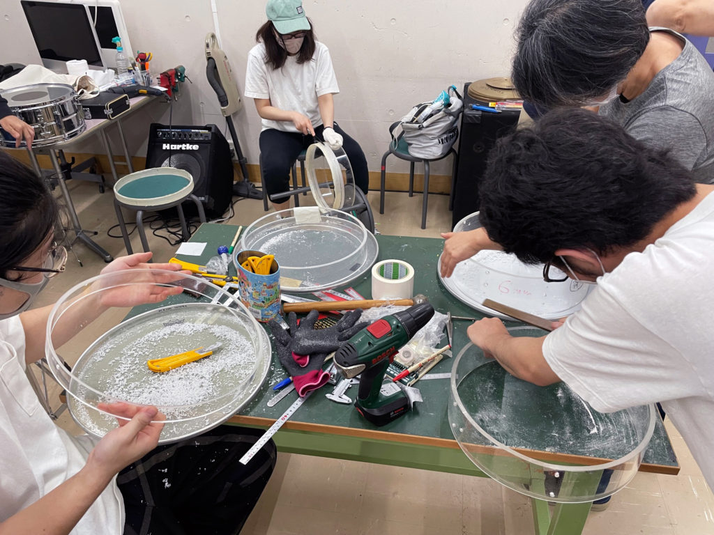 アクリルパイプを手作業で削りスネアのエッジ加工を学ぶ学生達